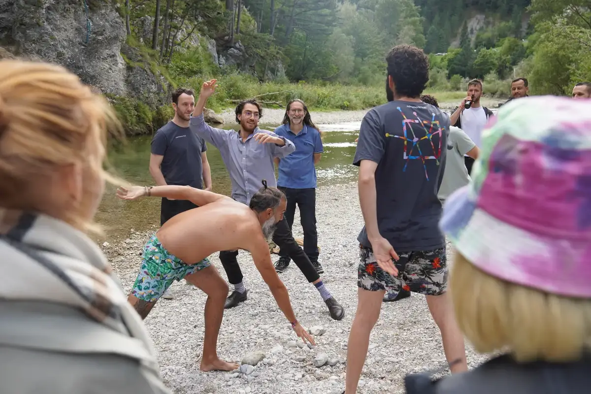 A group playing a game in a circle by the river
